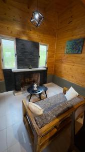a room with a bed and a table in a cabin at Cabaña Arashi in Tafí del Valle
