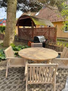 a wooden table and two chairs with a table and a grill at Sava Nida in Neringa