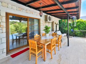 a wooden table and chairs on a patio at Villa Defne Kaş in Cukurbag
