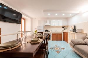 a kitchen with a wooden table with plates on it at Chill House mare bus e servizi a piedi in Procida