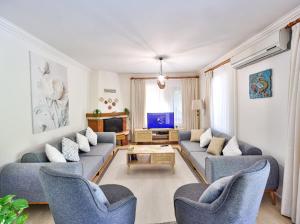 a living room with blue couches and a tv at Villa Defne Kaş in Cukurbag