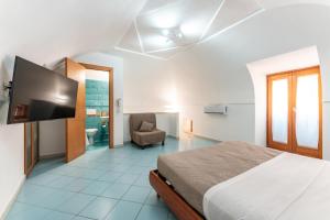 a bedroom with a bed and a flat screen tv at Chill House mare bus e servizi a piedi in Procida