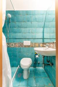 a blue tiled bathroom with a toilet and a sink at Chill House mare bus e servizi a piedi in Procida +27 photos
