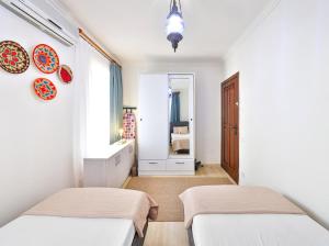 a white room with two beds and a window at Villa Defne Kaş in Cukurbag +10 photos