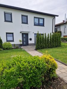 a white house with black windows and a driveway at Ferienwohnung in Olpe-Rhode am Biggesee in Olpe
