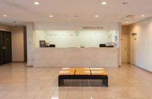 a waiting room with a bench in a lobby at Yono Daiichi Hotel in Saitama