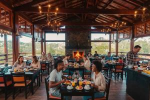 a group of people sitting at tables in a restaurant at Pousada Recanto dos Sonhos in Campos do Jordão