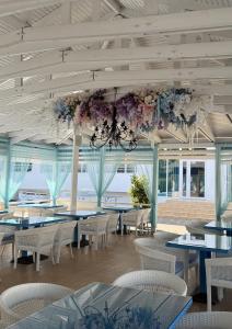 a dining room with tables and chairs and a chandelier at Villa Santorini in Zatoka