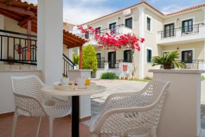 a patio with a table and chairs and a building at So Nice Hotel in Marathokampos