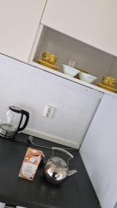 Eine Küchentheke mit einer Teekanne und Schüsseln auf einem Regal in der Unterkunft Hok Gård in Hok