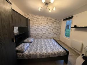 a bedroom with a bed in a room with a brick wall at Petit studio charmant in Lezoux