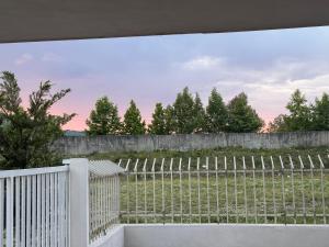 a white fence with a field behind it at Aisha Apartment in Berat