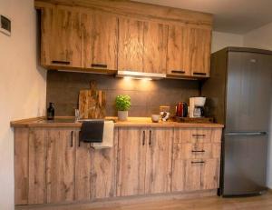 a kitchen with wooden cabinets and a refrigerator at Under Rock Guesthouse in Bled +6 photos