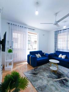 a living room with a blue couch and a table at Bella Accomodations, Mombasa in Bamburi