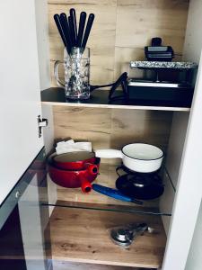 a cupboard with a kitchen utensils and a pot and pans at Le Chalet de la Coudre in Neuchâtel +13 photos