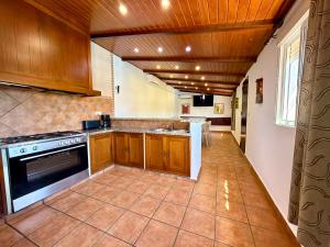 a kitchen with wooden cabinets and a stove at El Naranjo del Abuelo in Málaga +3 photos