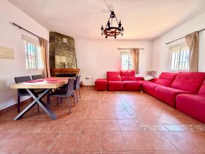 a living room with a red couch and a table at El Naranjo del Abuelo in Málaga