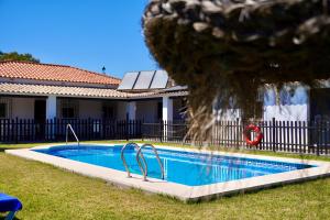 a swimming pool in a yard next to a house at El Naranjo del Abuelo in Málaga