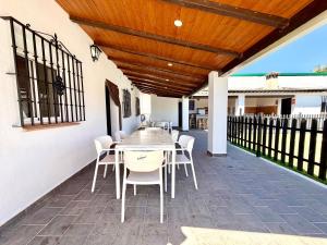 a patio with a wooden ceiling and a table and chairs at El Naranjo del Abuelo in Málaga