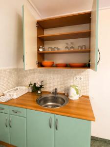 a kitchen counter with a sink and cabinets at Éden Panzio in Bük +79 photos