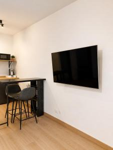 a room with a desk and a television on a wall at Nuara Urban Loft in Novara