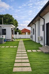 ein Garten mit Rasen und einem Steinweg in der Unterkunft Zenith House in Ibadan + 22 Fotos