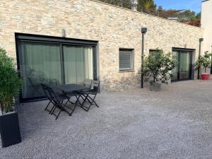 a patio with a table and chairs in front of a brick building at Douce Évasion in Beauvoisin