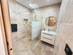 a bathroom with a shower and a sink and a mirror at Douce Évasion in Beauvoisin