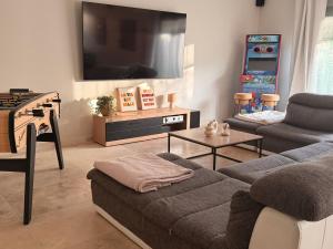 a living room with a couch and a tv at Douce Évasion in Beauvoisin