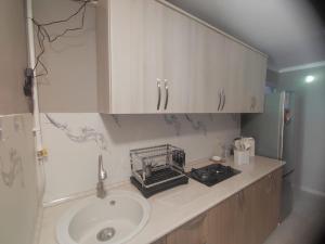 a bathroom with a sink and white cabinets and a counter at Eva Guesthouse in Odzun
