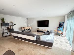 a living room with a couch and a flat screen tv at Douce Évasion in Beauvoisin