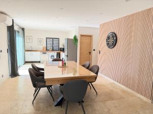 a dining room and kitchen with a table and chairs at Douce Évasion in Beauvoisin