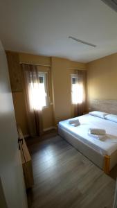 a bedroom with a large bed and two windows at Kron Apart Hotel Golem in Golem +55 photos