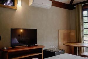 a bedroom with a flat screen tv and a bed at Villa Don in Petrópolis