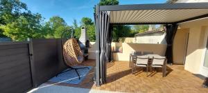 a patio with a table and chairs on a patio at Gite Rive Charente La Cabane in Bords