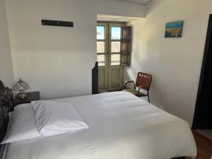 a white bed in a room with a window at Mansión del Parque by CS in Guaranda