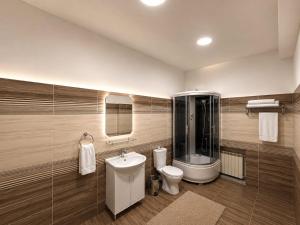 a bathroom with a toilet and a sink and a shower at Grand Sky Hotel in Almaty
