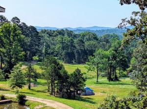 a tent in the middle of a field with trees at Ouachita Campground at Edendell in Oden