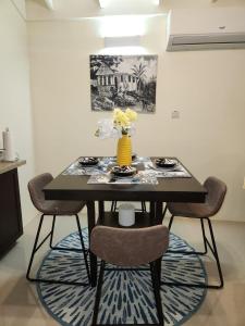 a dining room table with chairs and a vase with flowers at Honeycomb Oceanview Villa in Falmouth