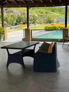 a table and a chair sitting next to a pool at Honeycomb Oceanview Villa in Falmouth