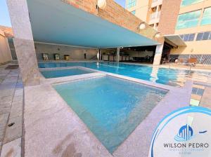 a swimming pool at a hotel with blue water at Piazza diRoma - Acqua Park e Splash in Caldas Novas +52 photos
