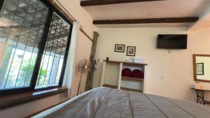 a bedroom with a bed and a large window at Hotel Posada La Vereda in Cuetzalán del Progreso