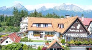 a building with a sign on it with mountains in the background at vila Barbara - Vysoké Tatry in Stará Lesná