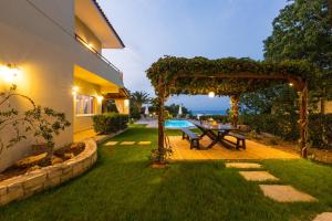 a backyard with a picnic table under a pergola at Malena Villa, beach retreat, By ThinkVilla in Sfakaki
