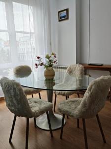 a dining room with a glass table and four chairs at Apartamento Leal Ferrol in Ferrol +7 photos