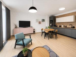 a living room with a table and chairs and a kitchen at Apartmán Hubertus No. 17 in Karlova Studánka