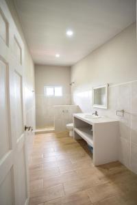 a white bathroom with a sink and a toilet at Blue Dream Kite Boarding Resort Costa Rica in Puerto Soley +57 photos