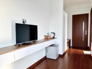 a living room with a flat screen tv on a wall at Saffron Boutique Hotel in Da Lat