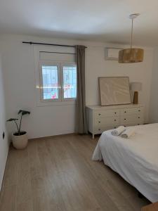 ein Schlafzimmer mit einem Bett, einer Kommode und einem Fenster in der Unterkunft Farelleta in Llança