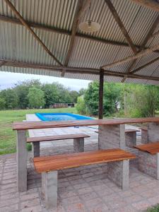 a picnic table and two benches under a pavilion at Cabañas Aires de Campo I in Victoria